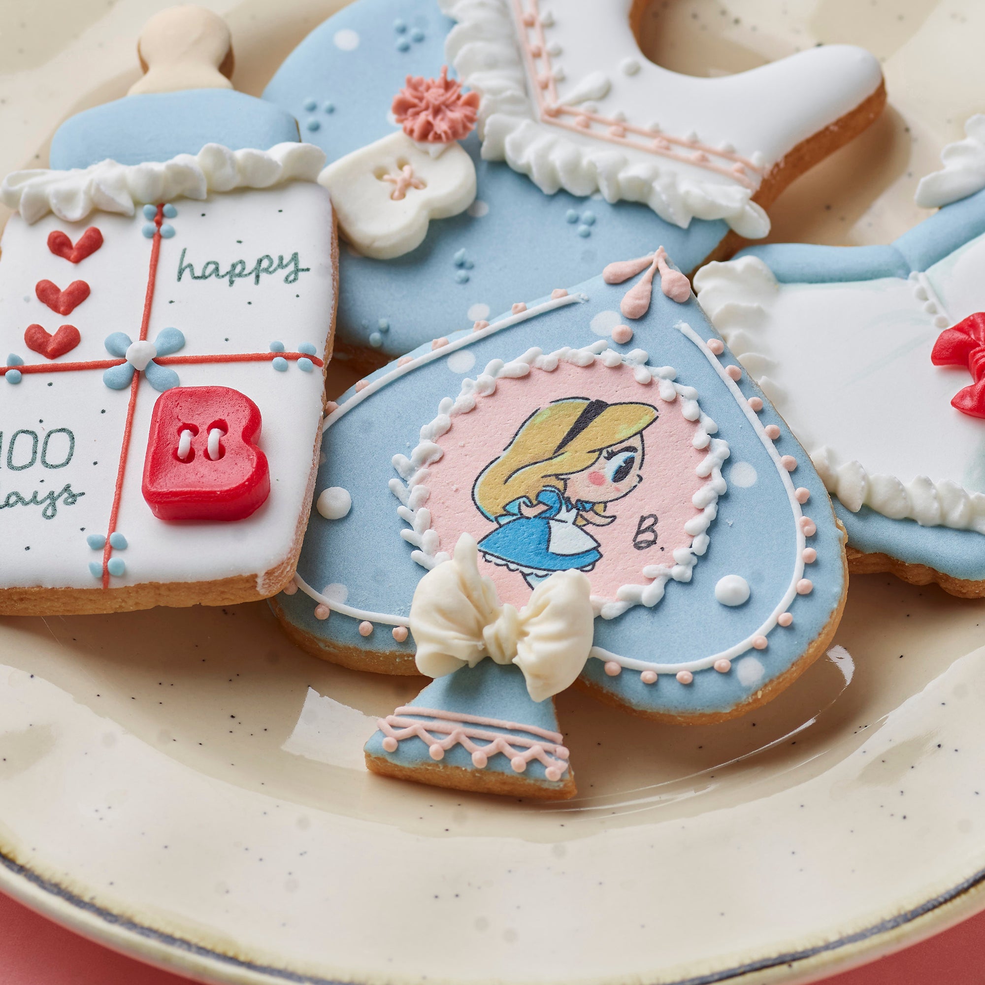 Amico 百日宴客製化蛋糕，以愛麗絲夢遊仙境為設計主題，搭配撲克牌、兔子與角色糖霜裝飾