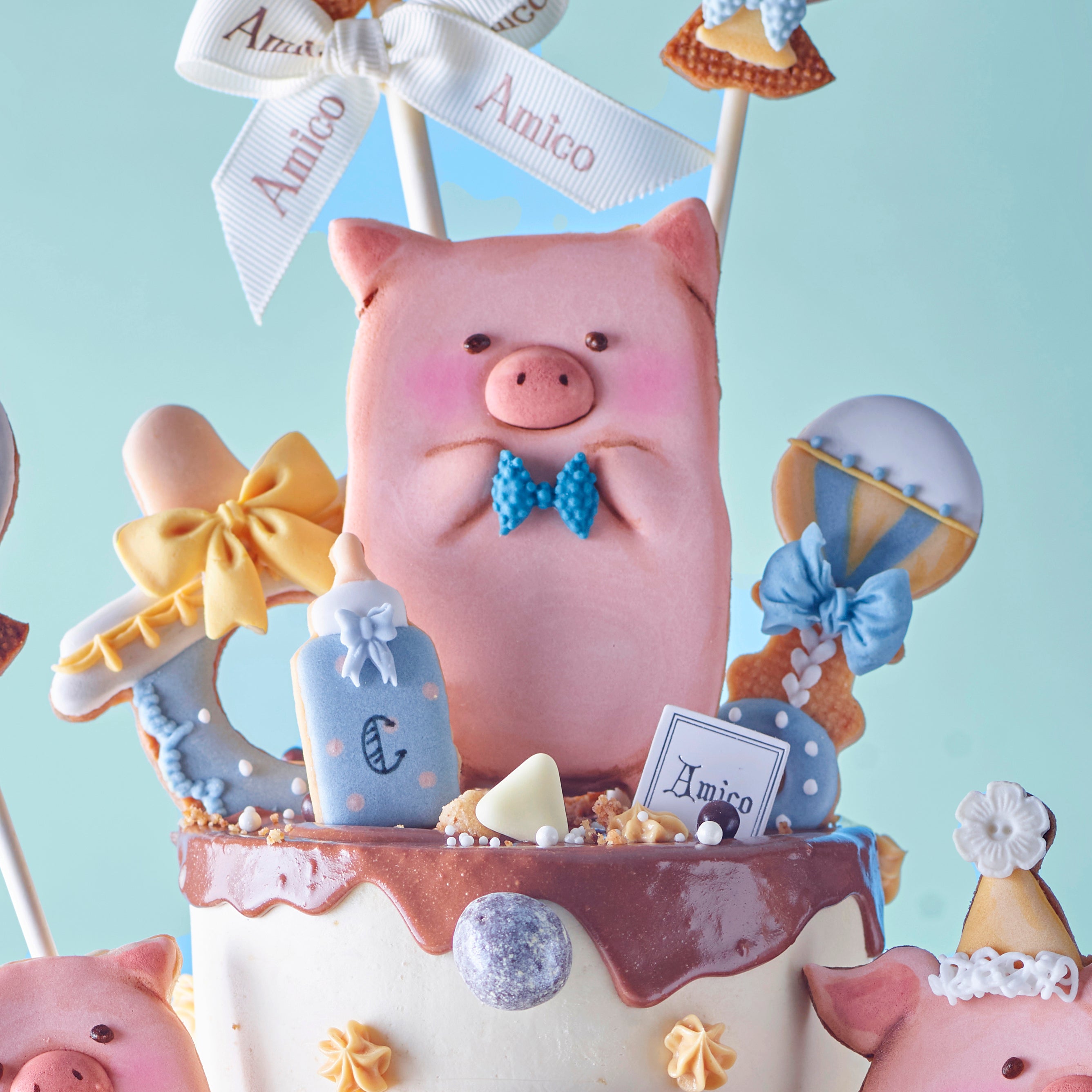 Amico LuLu 豬主題百日宴蛋糕，以可愛卡通小豬與氣球糖霜裝飾，慶祝寶寶 100 天特別時刻