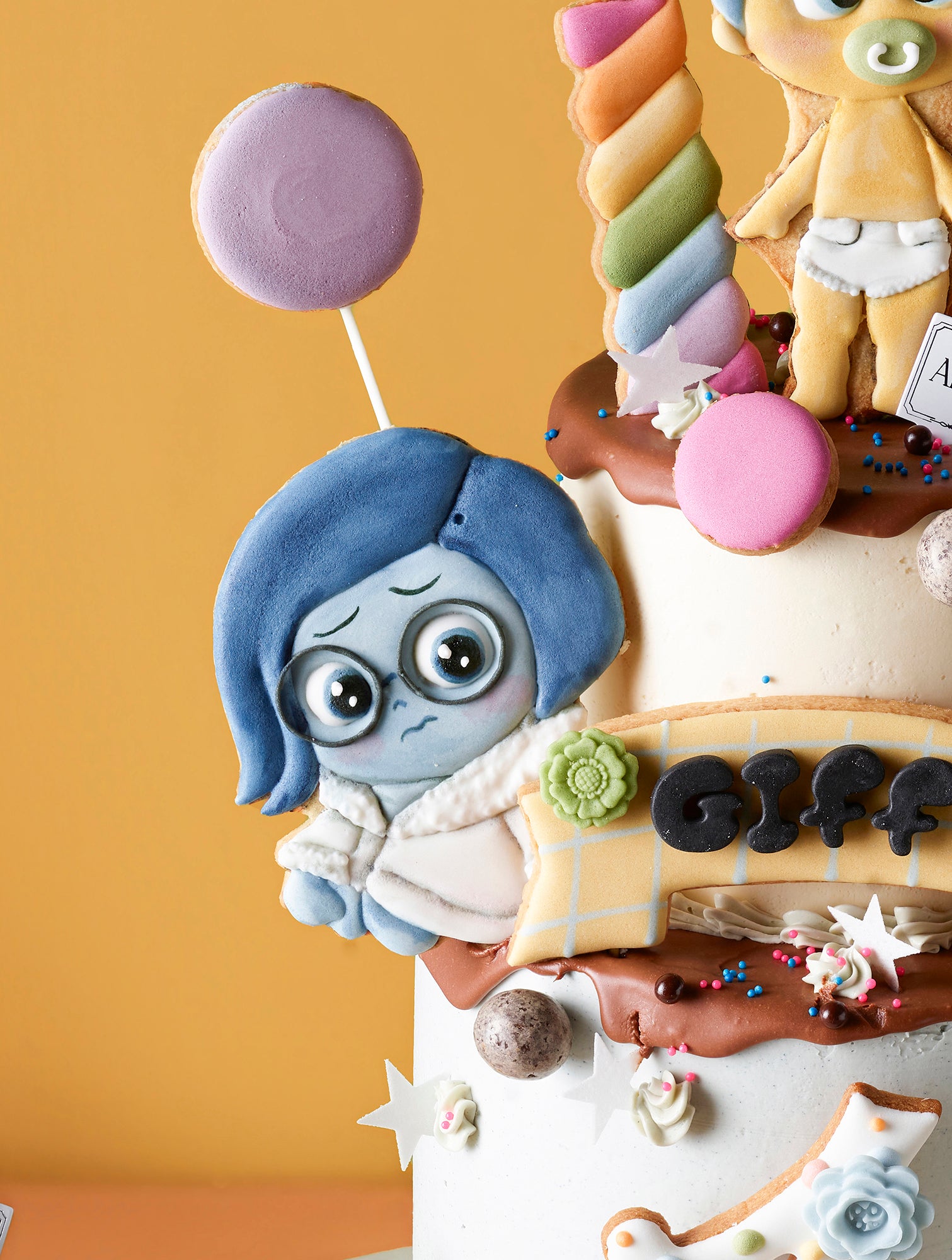 Amico Pasticceria 訂製《玩轉腦朋友》(Inside Out) 嬰兒主題大型派對套餐，專為一歲生日設計。包含一個以 BB 版阿愁 (Sadness)、阿樂 (Joy) 等角色及氣球裝飾的雙層專屬生日蛋糕，並搭配同主題的精緻杯子蛋糕，以及彩虹、奶瓶、嬰兒包屁衣造型的手工糖霜曲奇。